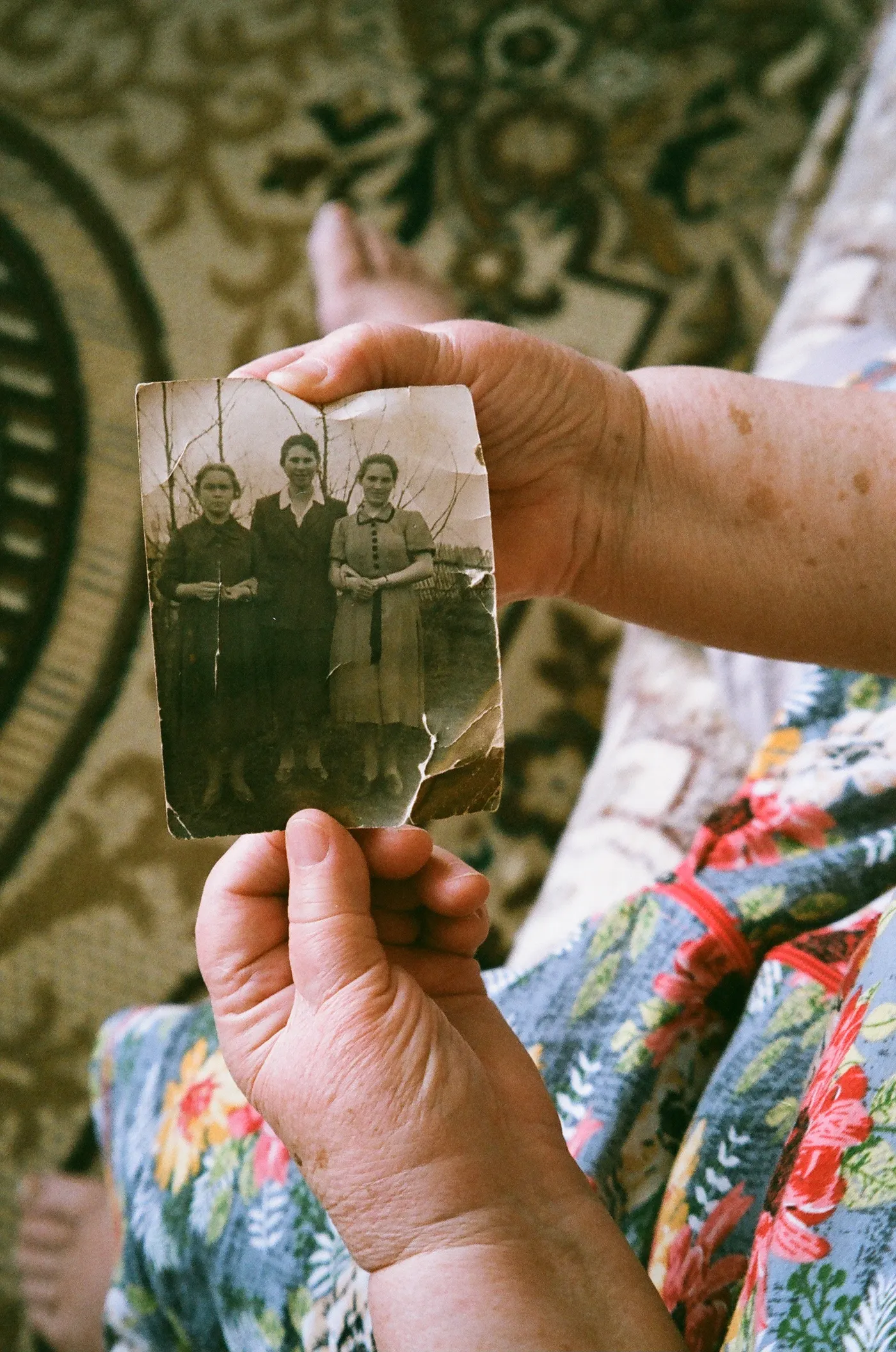 Older hands holding a treasured family photograph
